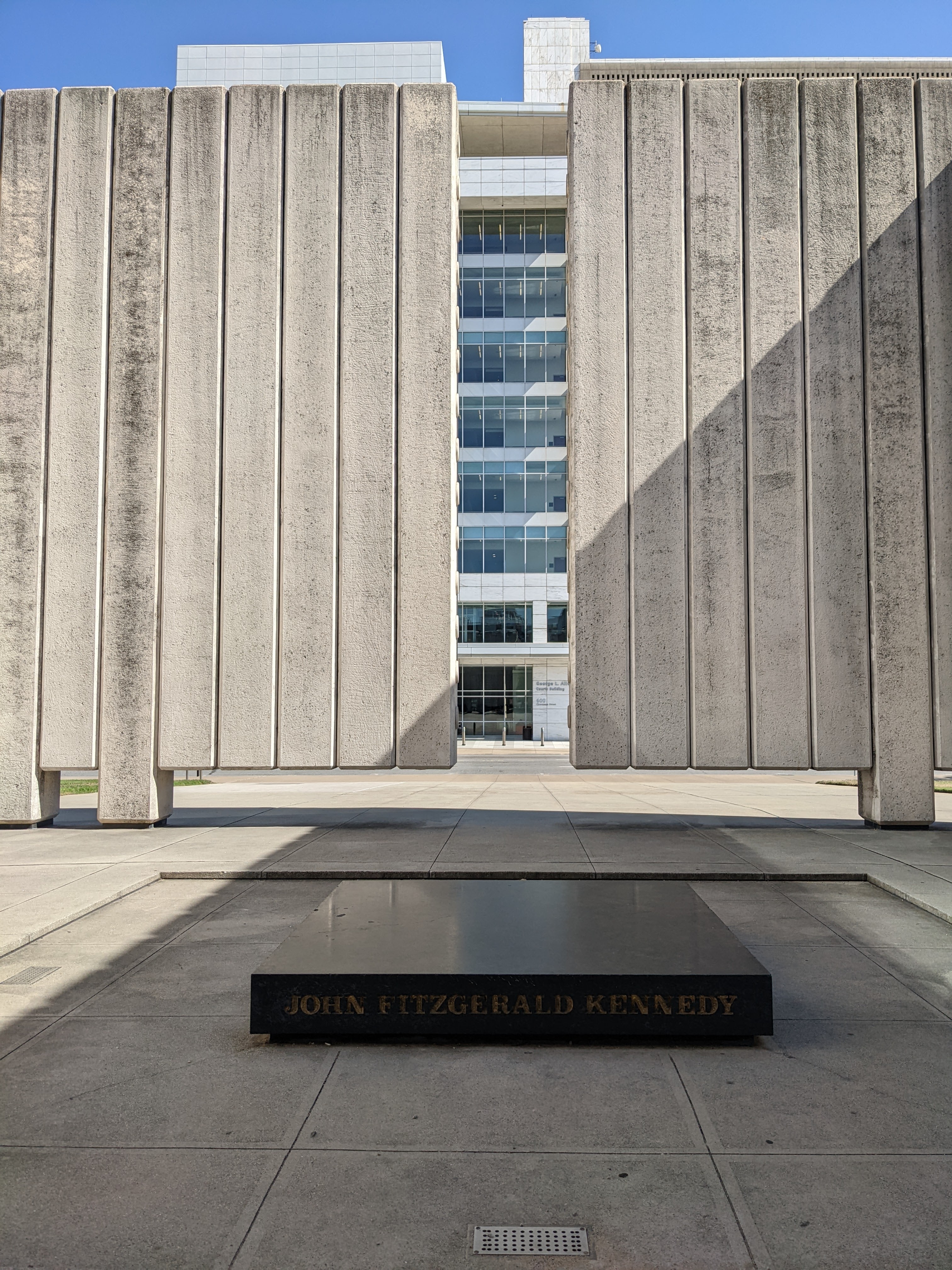 The sun slants into the imposing concrete walls that form the "open tomb" design of the JFK memorial
