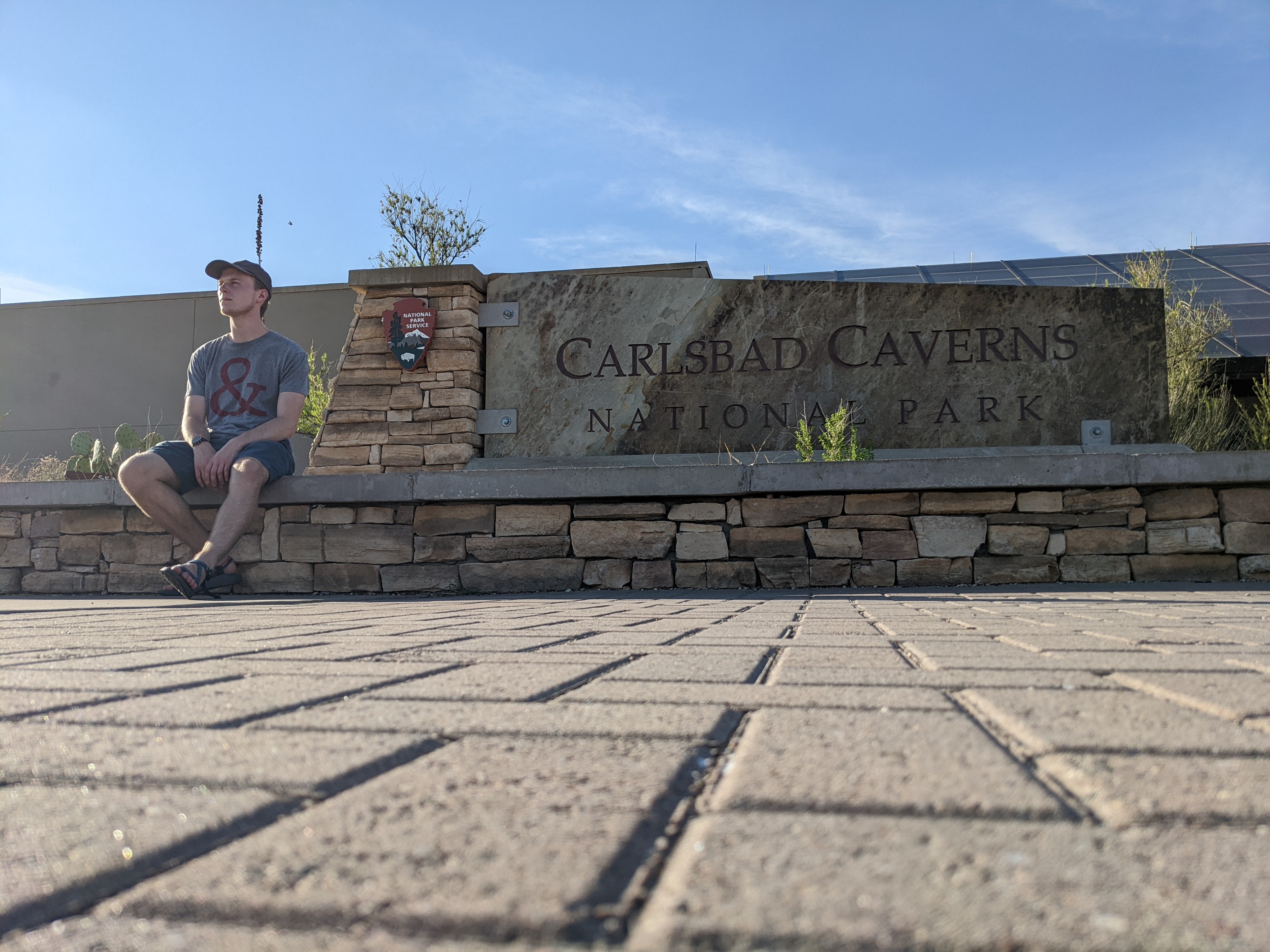 Kyle looking into distance next to Carlsbad Caverns National Park sign